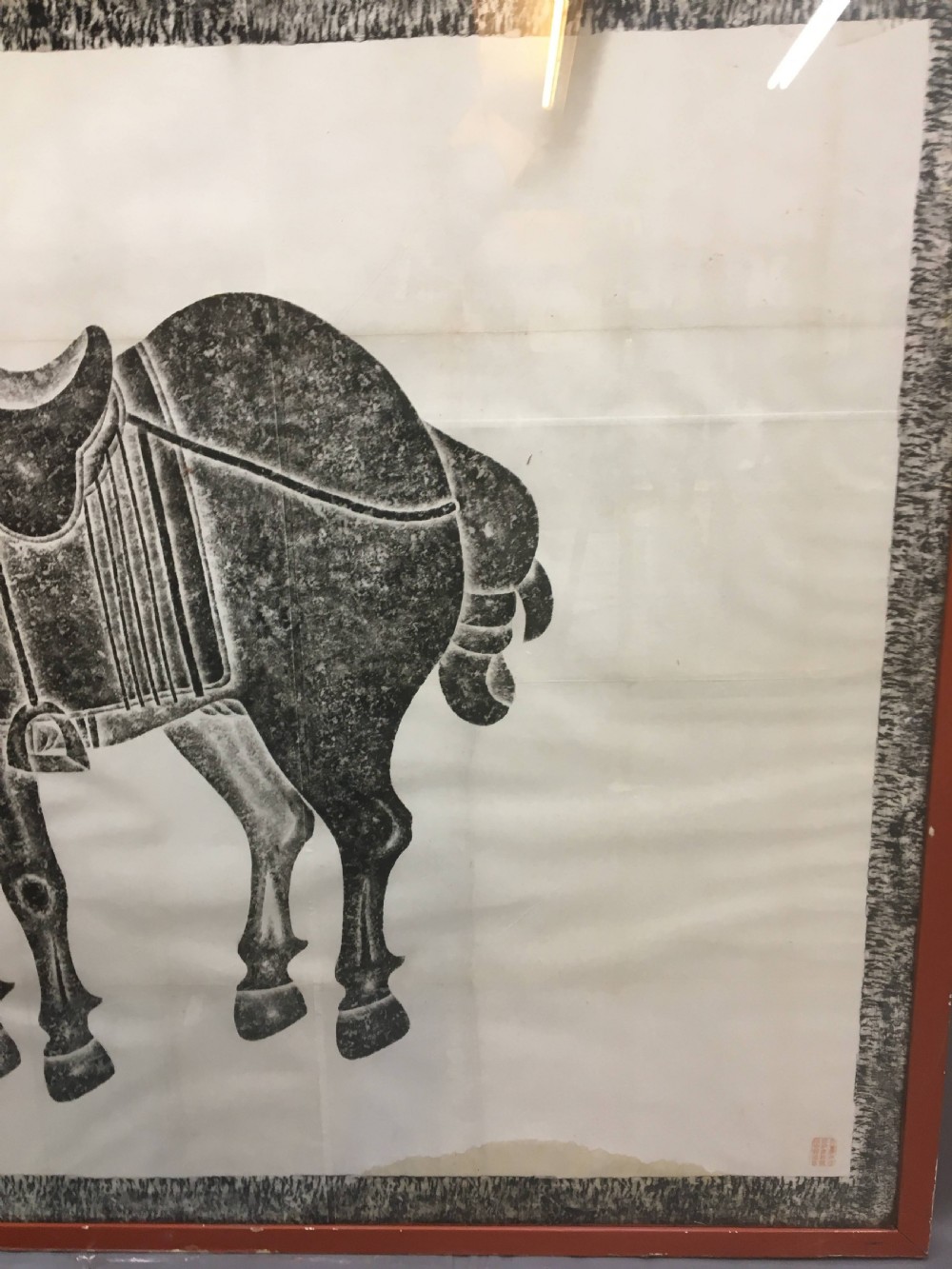 A large monochrome framed paper rubbing depicting a groom attending to a saddled Tang Dynasty horse. View XV