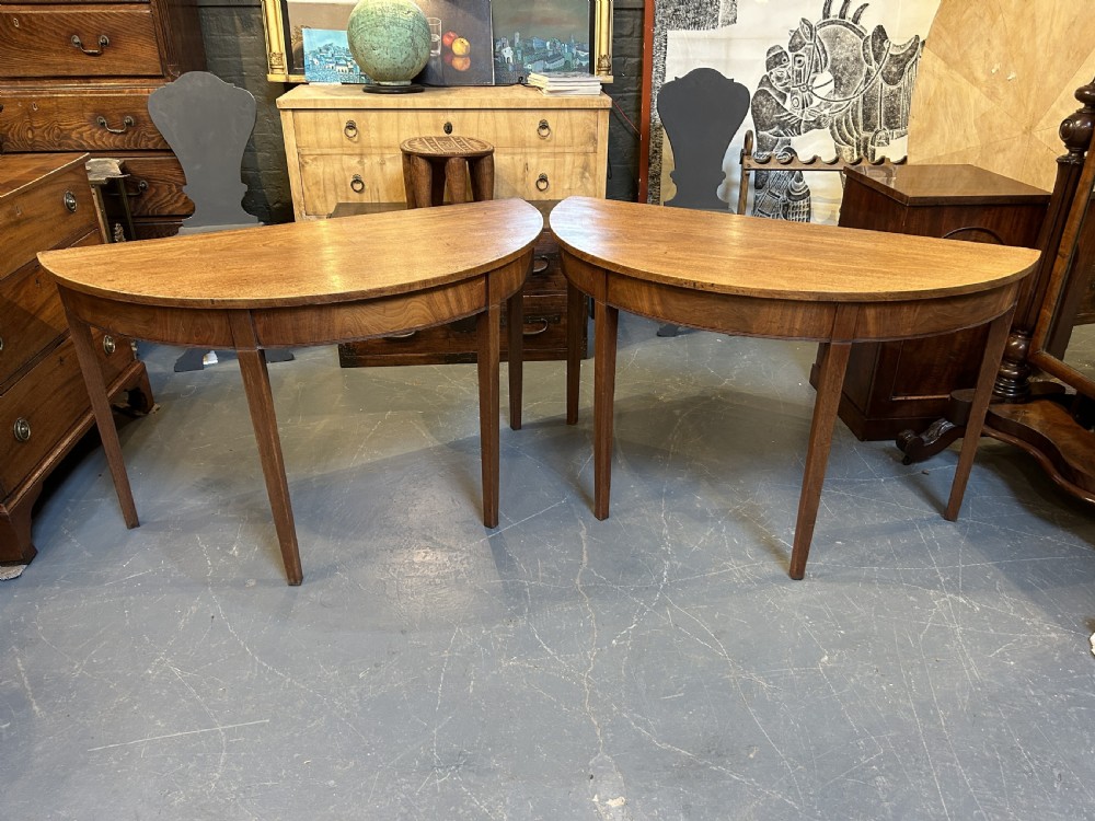 A pair of George III mahogany semi-circular demilune console tables supported by square tapered legs. View IX