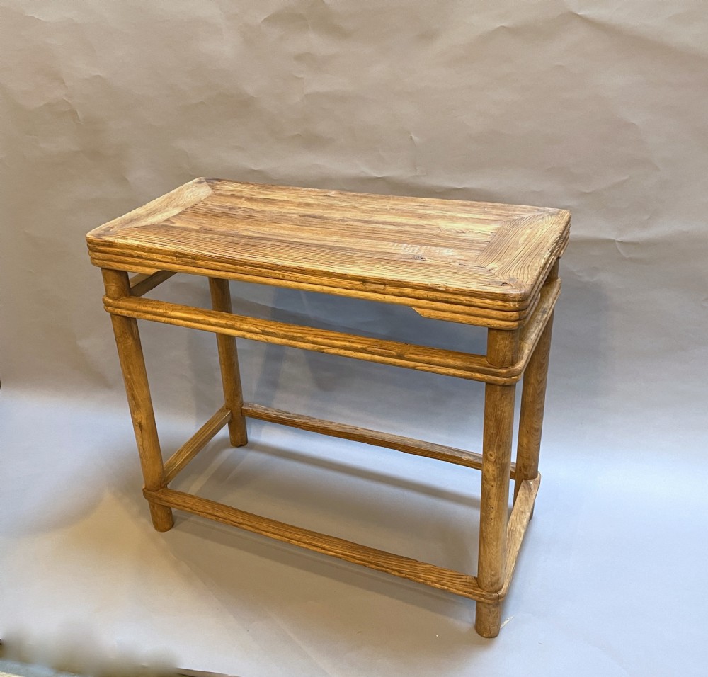 A 19th-century Chinese rectangular elm side table with double stretchers, natural wood grain, and straight cylindrical legs.