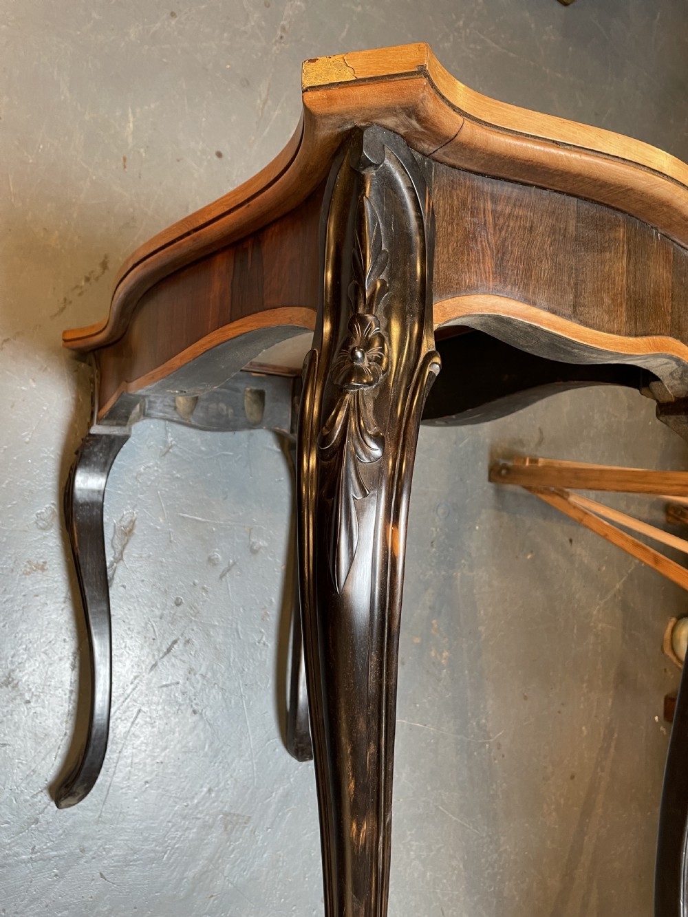 A 19th-century Ceylonese serpentine centre table featuring dark hardwood construction, a light wood crossbanded top, and carved cabriole legs. View X