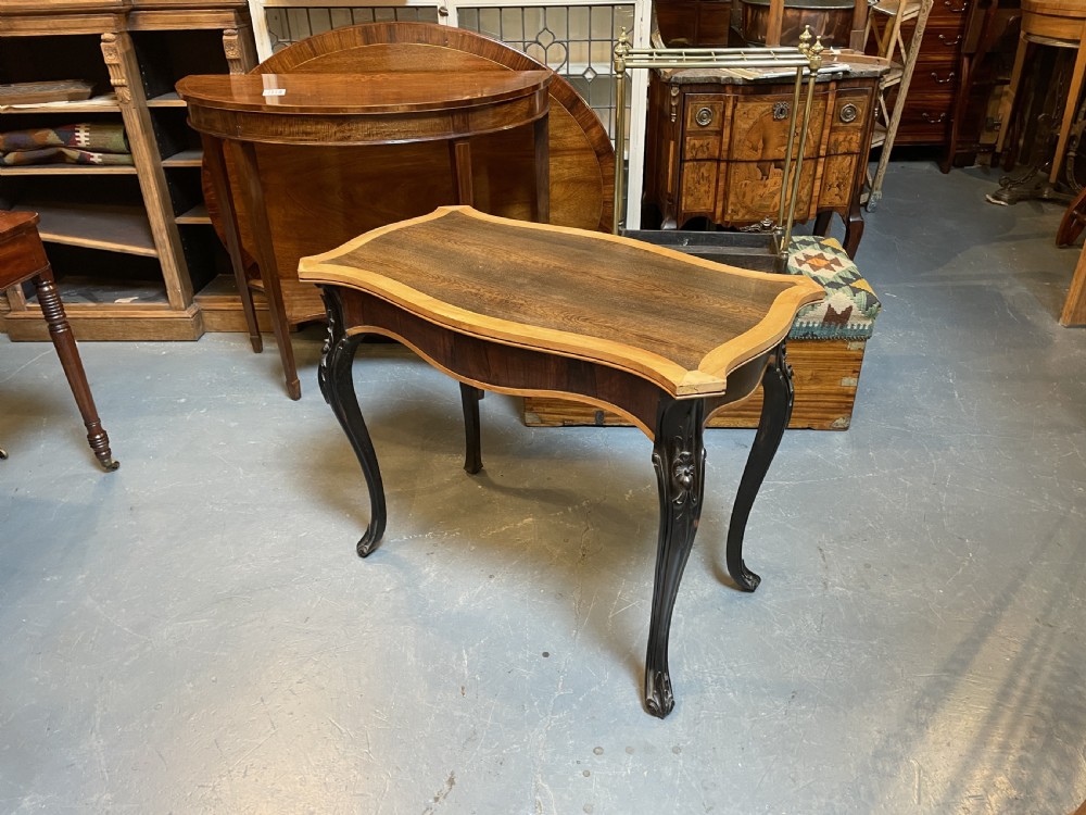 A 19th-century Ceylonese serpentine centre table featuring dark hardwood construction, a light wood crossbanded top, and carved cabriole legs. View XII