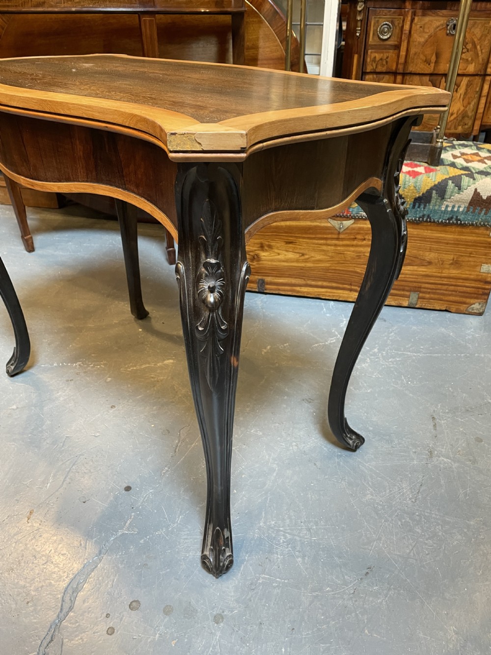 A 19th-century Ceylonese serpentine centre table featuring dark hardwood construction, a light wood crossbanded top, and carved cabriole legs. View XIII