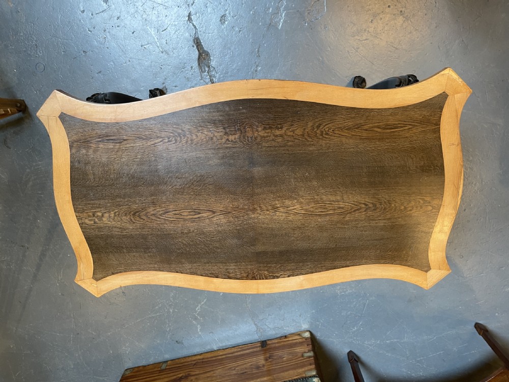 A 19th-century Ceylonese serpentine centre table featuring dark hardwood construction, a light wood crossbanded top, and carved cabriole legs. View XIV