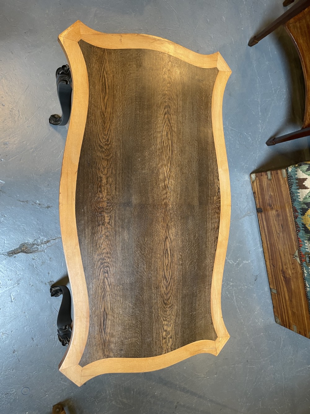 A 19th-century Ceylonese serpentine centre table featuring dark hardwood construction, a light wood crossbanded top, and carved cabriole legs. View XV