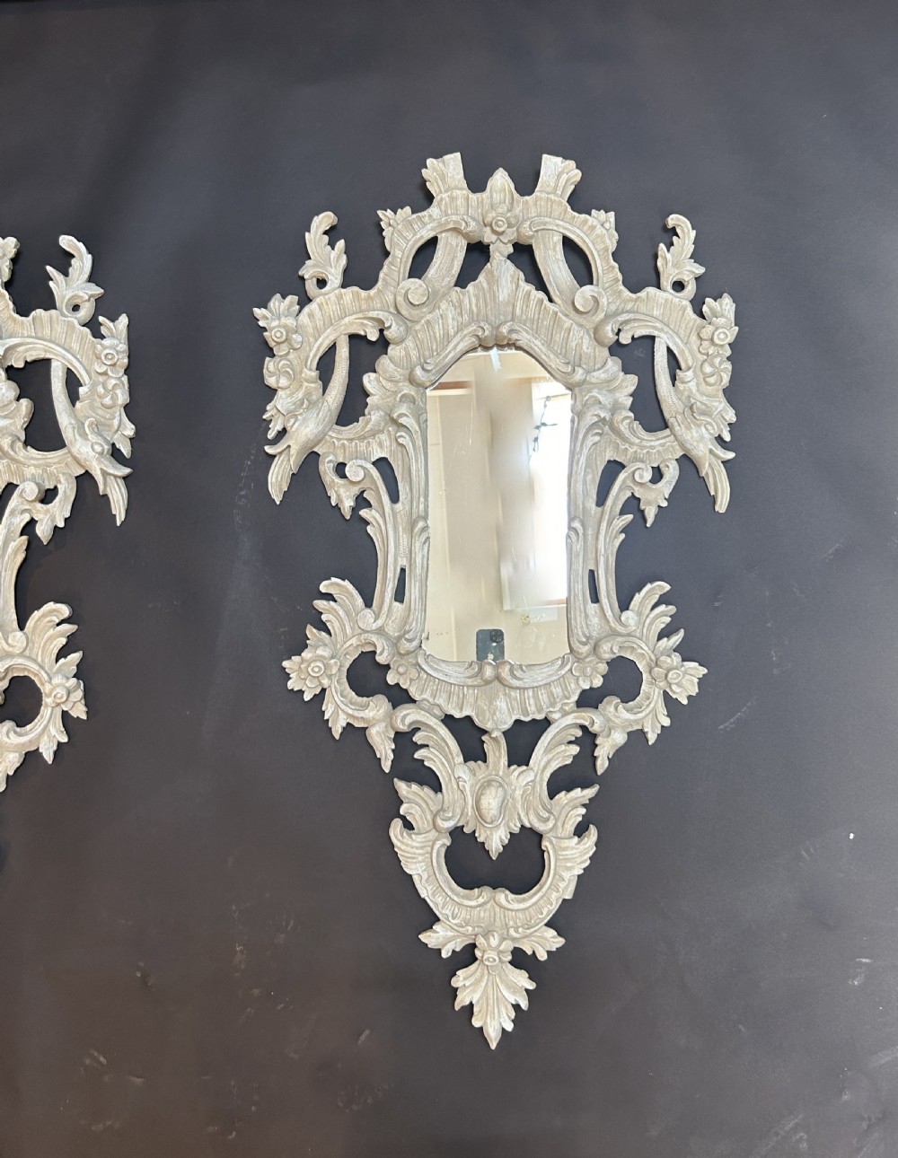 A 19th-century Continental wall mirror with an ornate carved off-white frame featuring intricate scrollwork, acanthus leaves, and shell motifs. View II