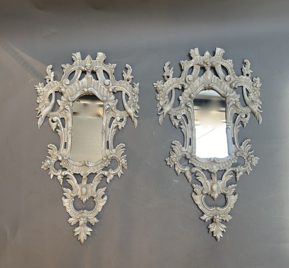 A 19th-century Continental wall mirror with an ornate carved off-white frame featuring intricate scrollwork, acanthus leaves, and shell motifs. View VIII