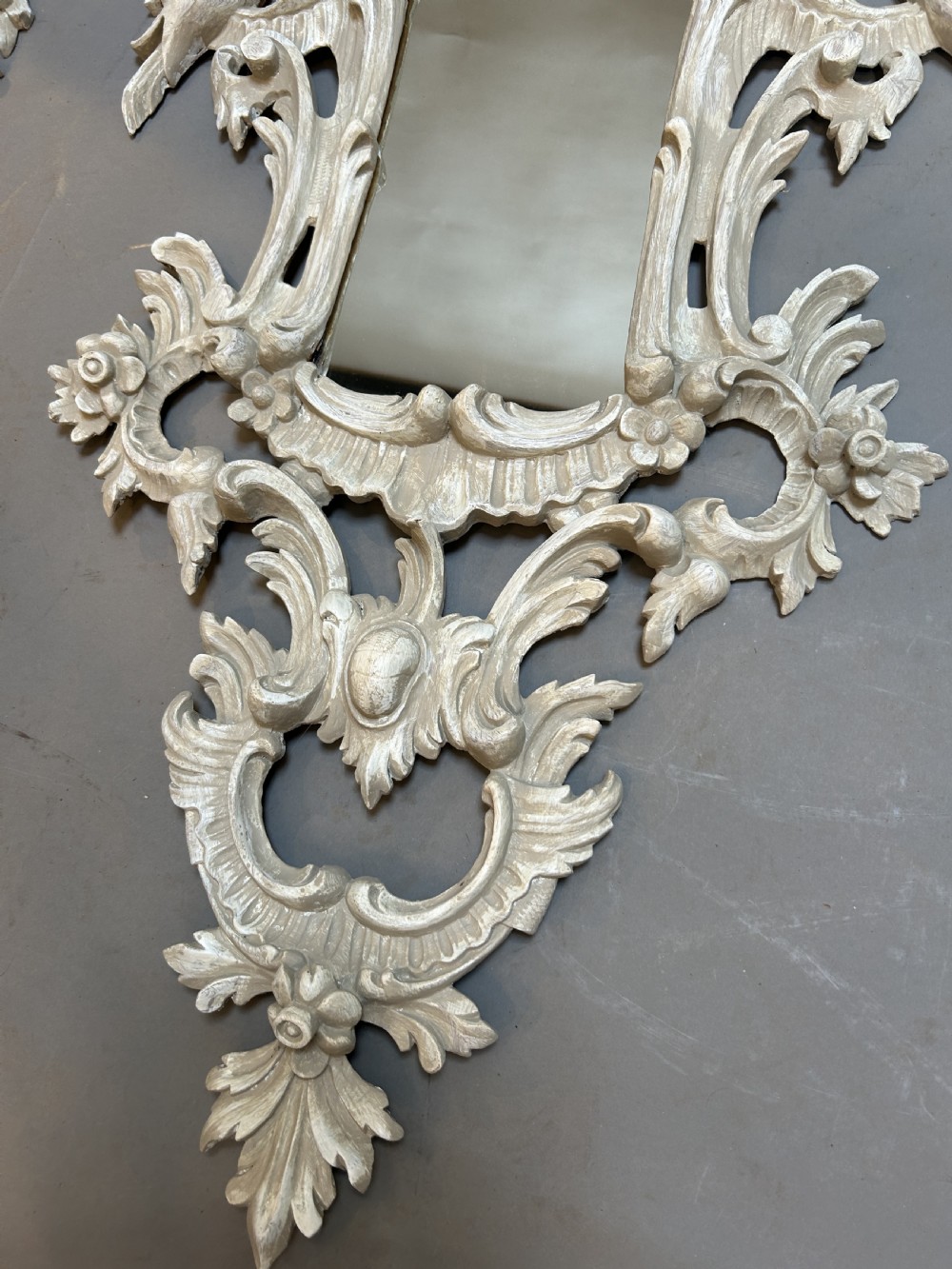 A 19th-century Continental wall mirror with an ornate carved off-white frame featuring intricate scrollwork, acanthus leaves, and shell motifs. View IX