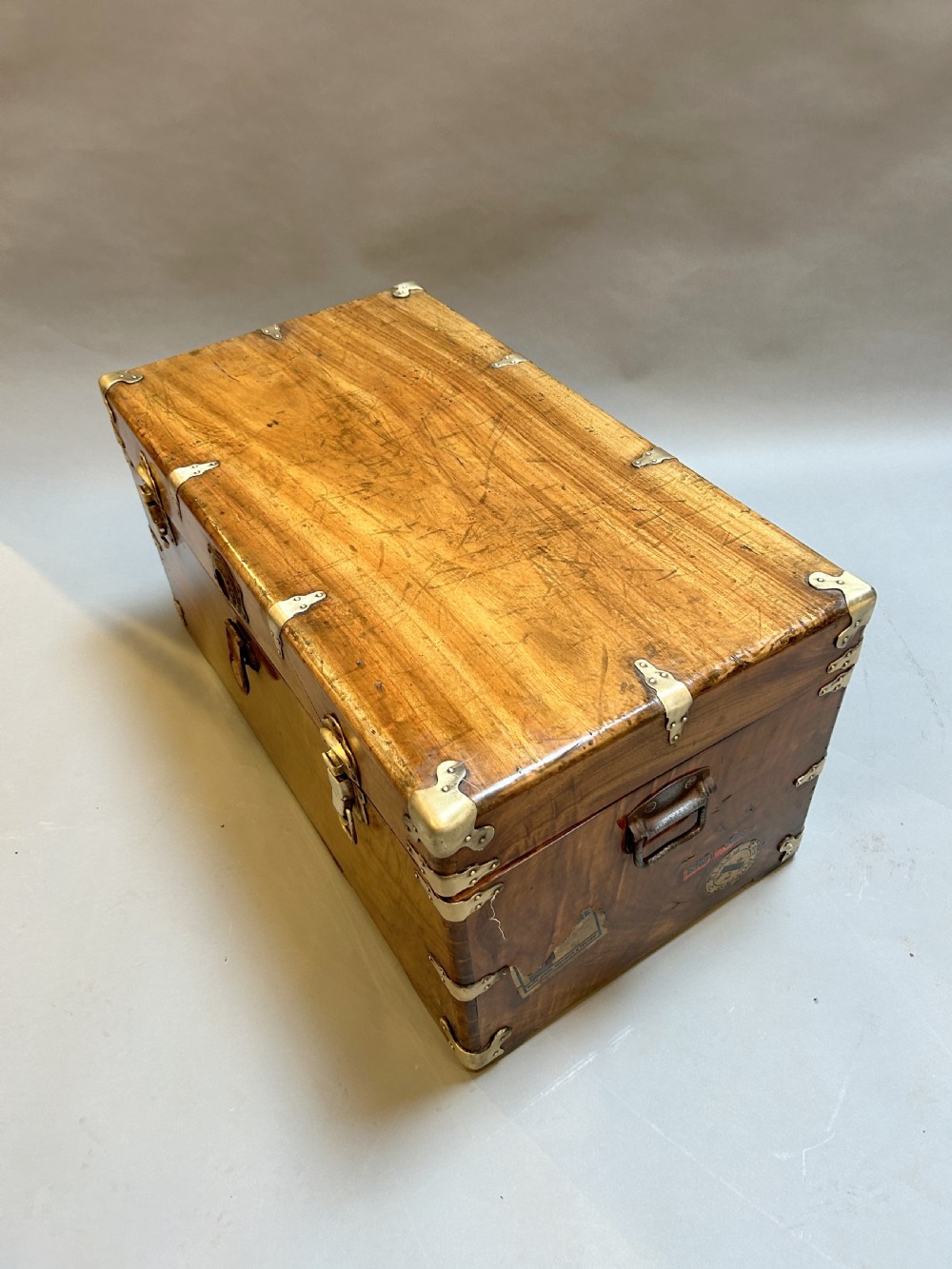 A rectangular solid camphor wood steamer trunk featuring metal corner brackets, metal latches, and side carrying handles. View II