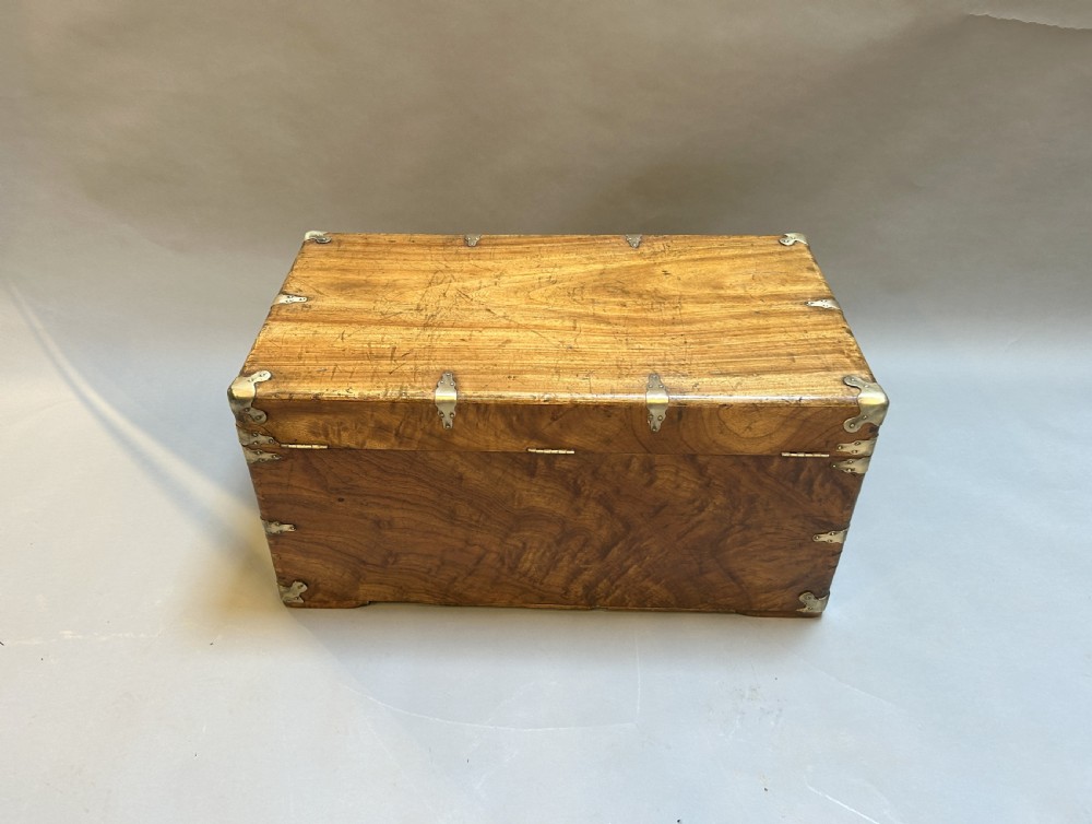 A rectangular solid camphor wood steamer trunk featuring metal corner brackets, metal latches, and side carrying handles. View V