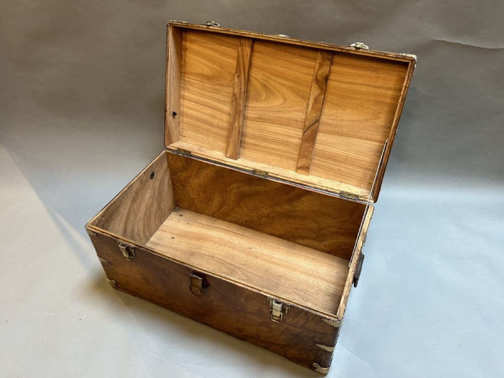 A rectangular solid camphor wood steamer trunk featuring metal corner brackets, metal latches, and side carrying handles. View X