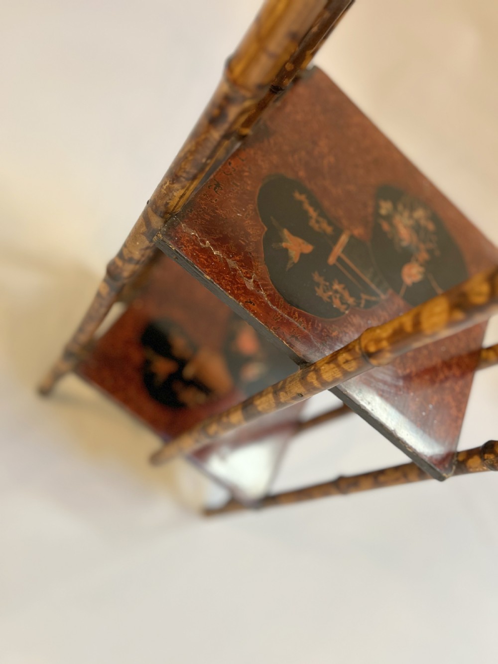 A three-tiered late Victorian bamboo side table featuring a mottled finish, square lacquered shelves decorated with fan motifs, and an overarching top handle. View II
