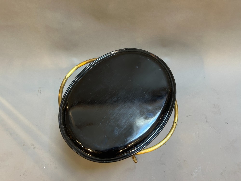 An oval black lacquered papier-mache tray table with detailed gilt scrollwork, supported on a brass faux-bamboo base with an X-stretcher. View IV