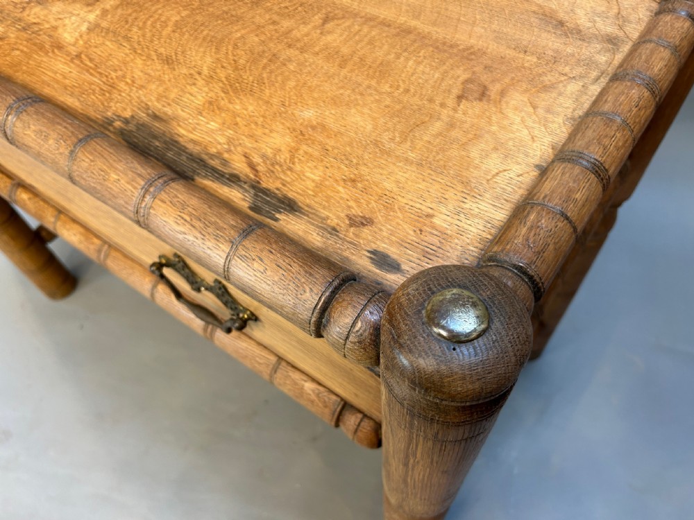 A 19th-century medium oak side table featuring ring-turned legs, a single drawer with brass drop handles, and a raised turned wooden gallery edge. View II