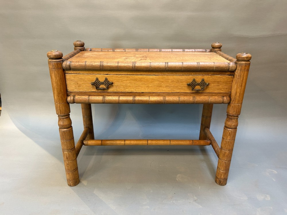 A 19th-century medium oak side table featuring ring-turned legs, a single drawer with brass drop handles, and a raised turned wooden gallery edge. View IV