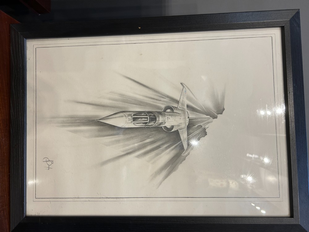 A pair of framed monochrome pencil sketches depicting jet aircraft in high-speed motion, one oriented horizontally and the other vertically. View II