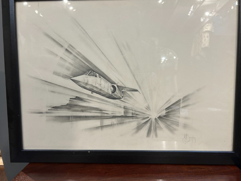 A pair of framed monochrome pencil sketches depicting jet aircraft in high-speed motion, one oriented horizontally and the other vertically. View III