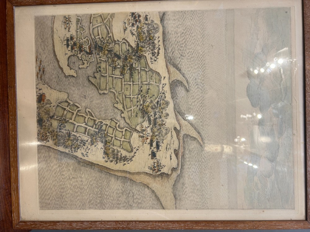 A pair of framed 19th-century prints displaying detailed topographical military formations and coastal maps in matching wooden frames. View II