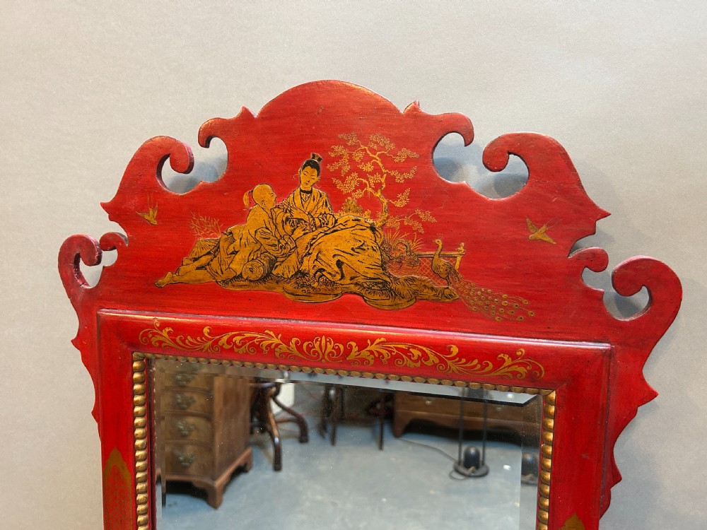 A tall rectangular red lacquered wall mirror featuring intricate gilt Chinoiserie motifs and a scrolled carved pediment. View III