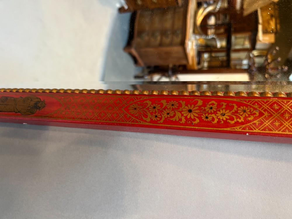 A tall rectangular red lacquered wall mirror featuring intricate gilt Chinoiserie motifs and a scrolled carved pediment. View V