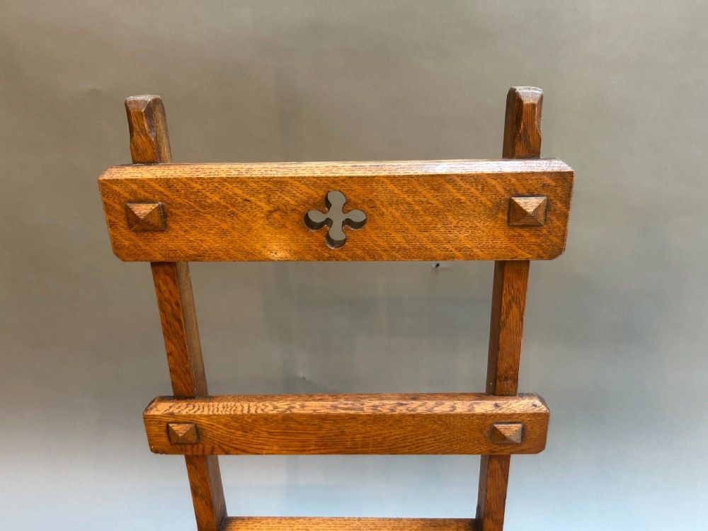 An antique solid oak metamorphic chair that folds into library steps, featuring a pierced trefoil motif backrest and square legs. View IV