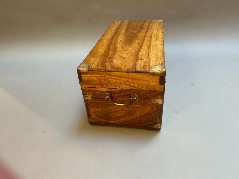 A small nineteenth-century camphor wood campaign trunk with brass corner mounts, flush handles, and keyhole escutcheon. View X