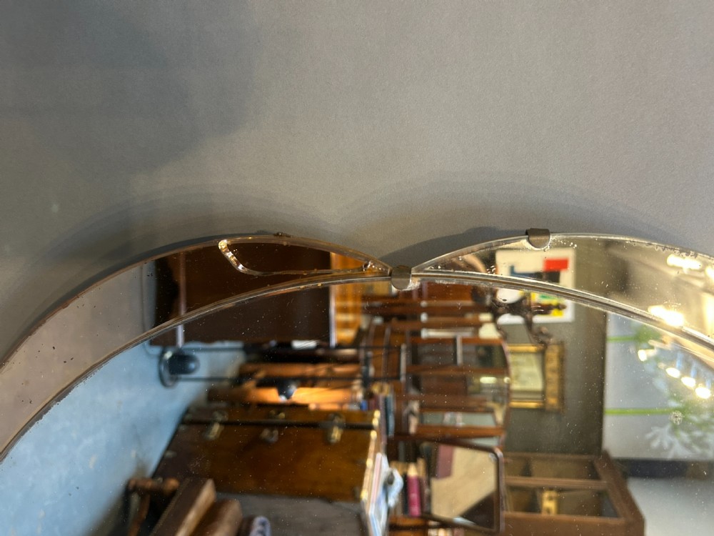 A circular Art Deco wall mirror featuring scalloped outer sectional mirror panels and suspended by a metal hanging chain. View II