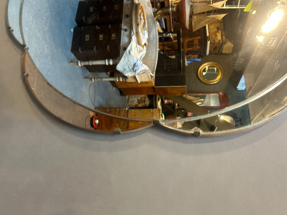 A circular Art Deco wall mirror featuring scalloped outer sectional mirror panels and suspended by a metal hanging chain. View III