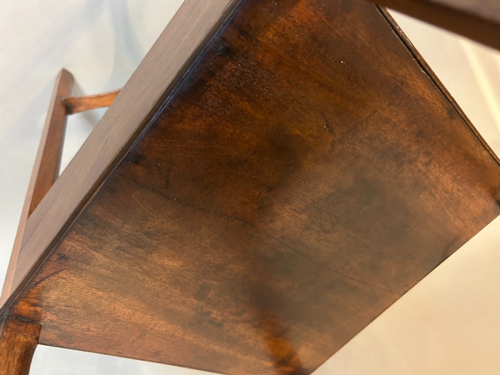 A George III mahogany nightstand featuring a shaped gallery top tier, an open middle shelf, a single drawer with a brass knob, and a shaped cross stretcher at the base. View III