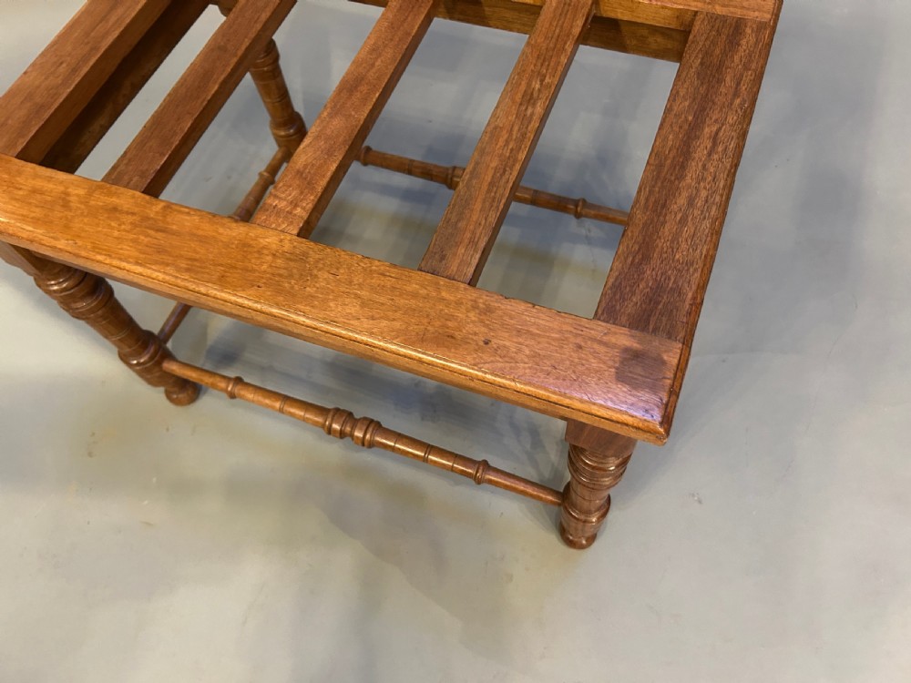 A Victorian wooden luggage stand featuring a slatted top surface supported by four turned legs with horizontal turned stretchers. View II