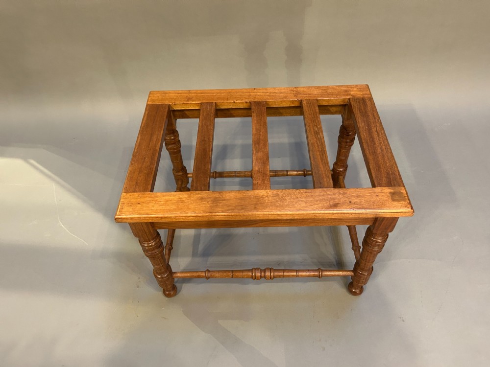 A Victorian wooden luggage stand featuring a slatted top surface supported by four turned legs with horizontal turned stretchers. View IV