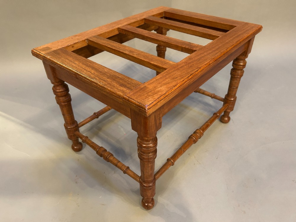 A Victorian wooden luggage stand featuring a slatted top surface supported by four turned legs with horizontal turned stretchers. View VII