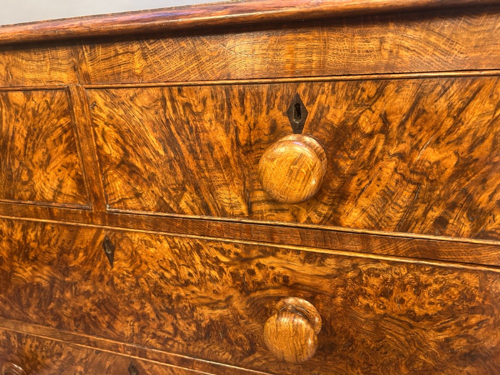 An antique country oak chest of drawers featuring six graduated drawers with turned wooden handles and bracket feet. View II
