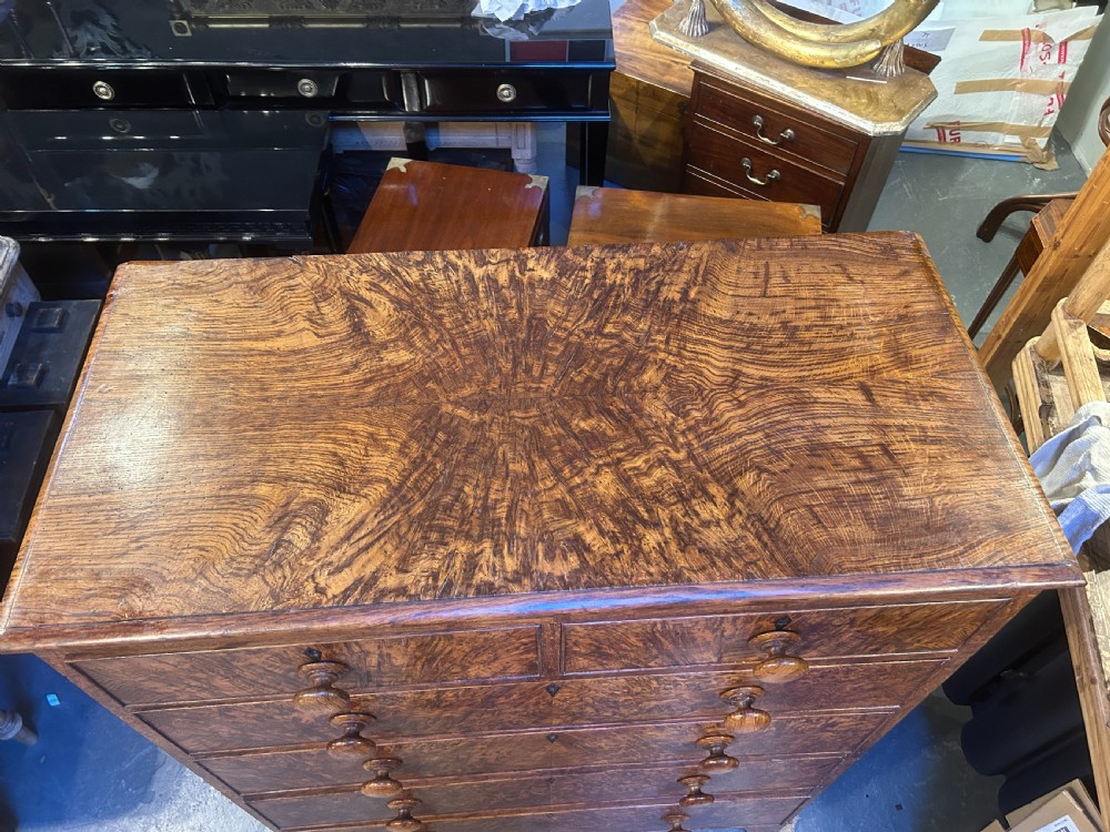 An antique country oak chest of drawers featuring six graduated drawers with turned wooden handles and bracket feet. View VII