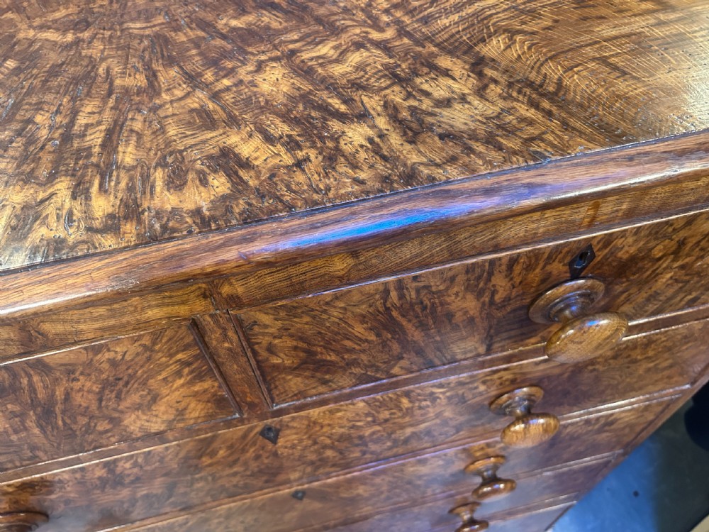 An antique country oak chest of drawers featuring six graduated drawers with turned wooden handles and bracket feet. View VIII