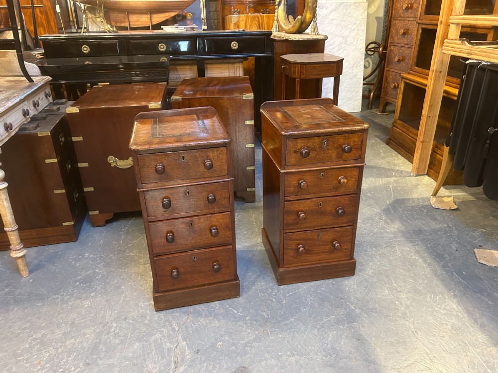 A pair of matching Victorian mahogany narrow bedside chests featuring four drawers with turned wooden knobs and leather inset tops. View XI