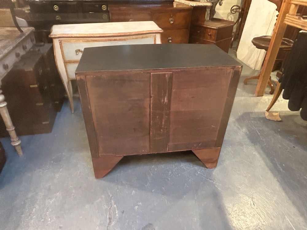 A Regency period ebonised bow-front chest of drawers featuring two short over two long drawers with brass drop handles and bracket feet. View XI