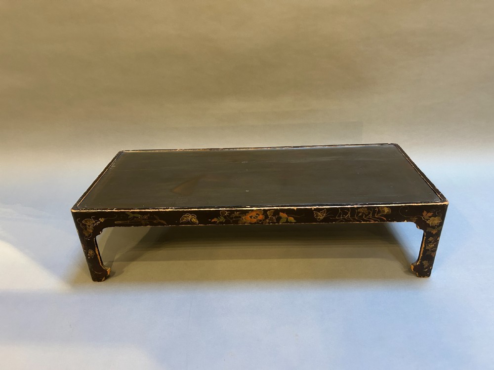 A low rectangular antique Chinese black lacquered coffee table decorated with hand-painted floral motifs and corner apron detail. View III
