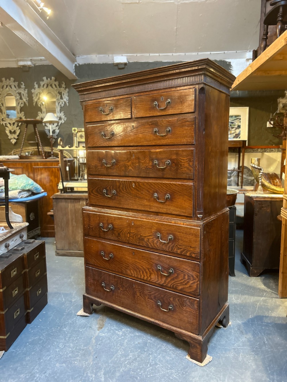 A tall George III oak chest-on-chest featuring two short over three long drawers on the upper section, three long drawers on the lower section, brass swan-neck handles, and bracket feet. View VI
