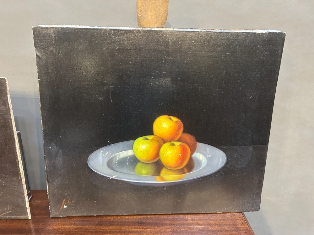 A pair of Spanish still-life oil paintings depicting apples, a pewter plate, and a glass of water against a dark background. View II