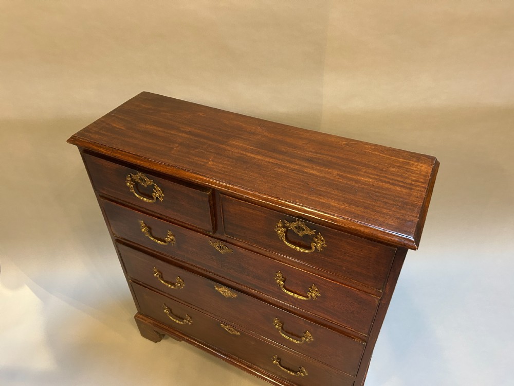 A George III dark mahogany hall chest of drawers featuring brass swan-neck handles, keyhole escutcheons, and bracket feet. View II
