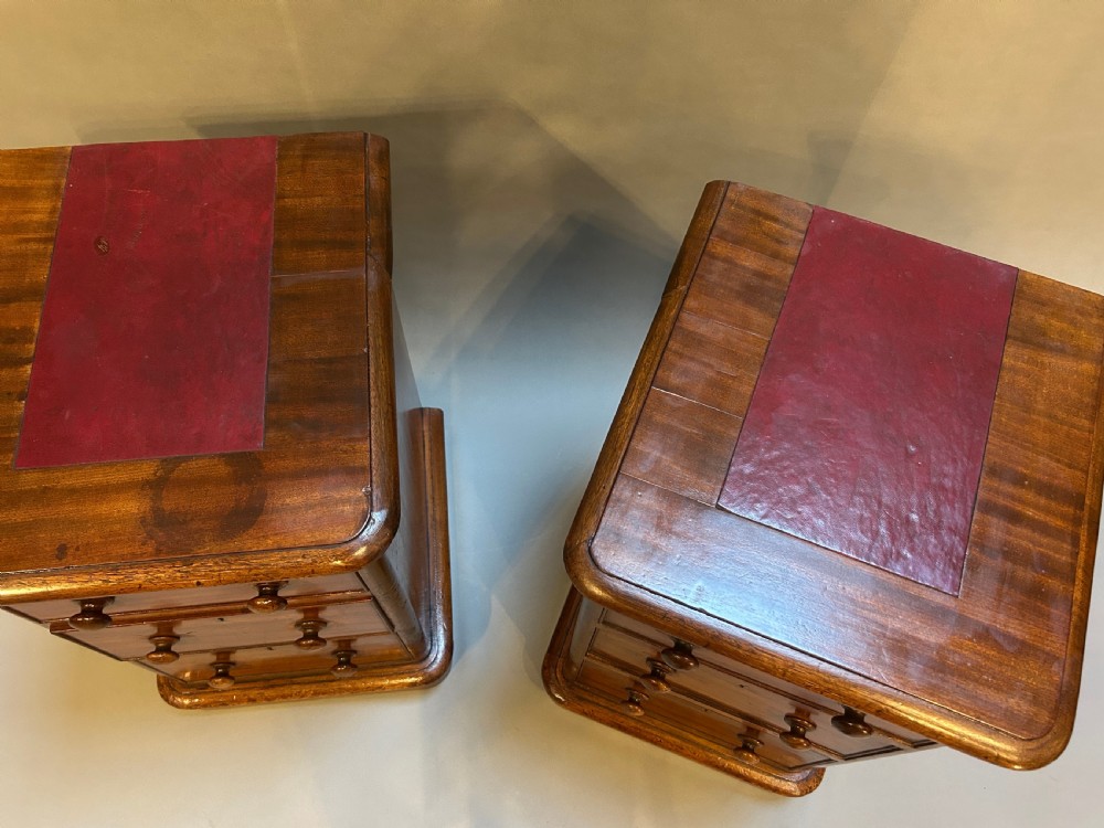 A pair of matching Victorian mahogany bedside chests of drawers featuring inset red leather tops and three drawers with turned wooden knobs. View IV