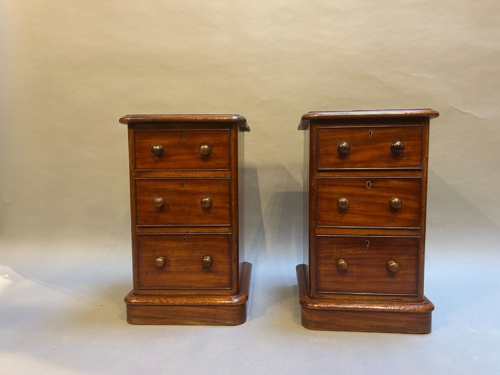 A pair of matching Victorian mahogany bedside chests of drawers featuring inset red leather tops and three drawers with turned wooden knobs. View VII