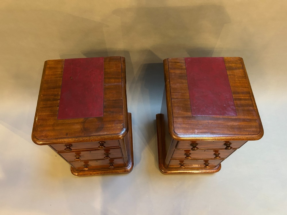 A pair of matching Victorian mahogany bedside chests of drawers featuring inset red leather tops and three drawers with turned wooden knobs. View VIII