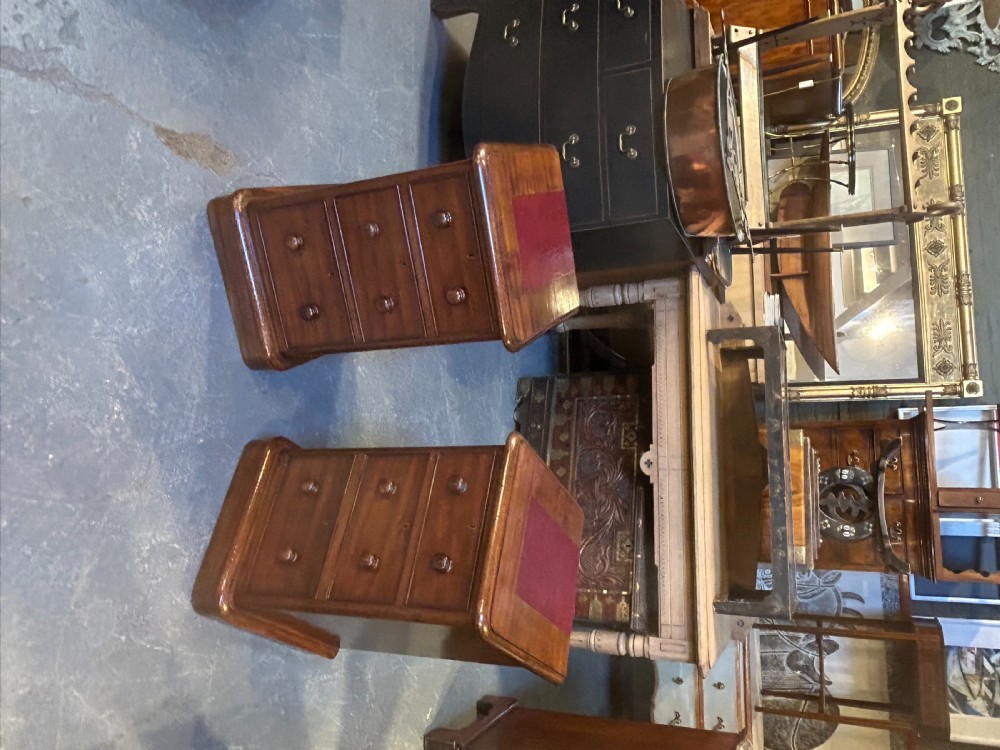 A pair of matching Victorian mahogany bedside chests of drawers featuring inset red leather tops and three drawers with turned wooden knobs. View IX