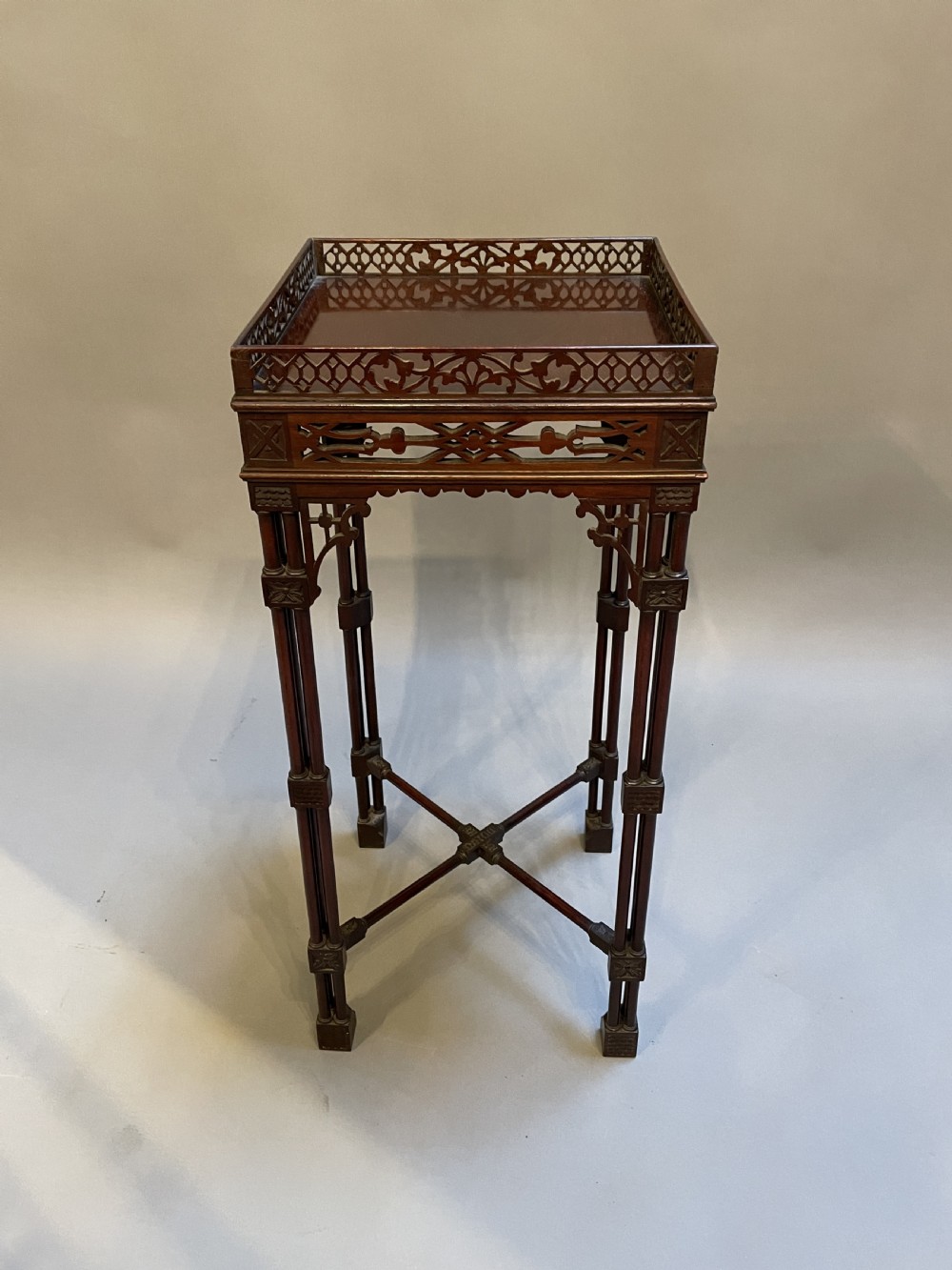A tall mahogany Chippendale revival lamp table featuring a pierced fretwork gallery top, clustered column legs, and an X-form stretcher. View IV