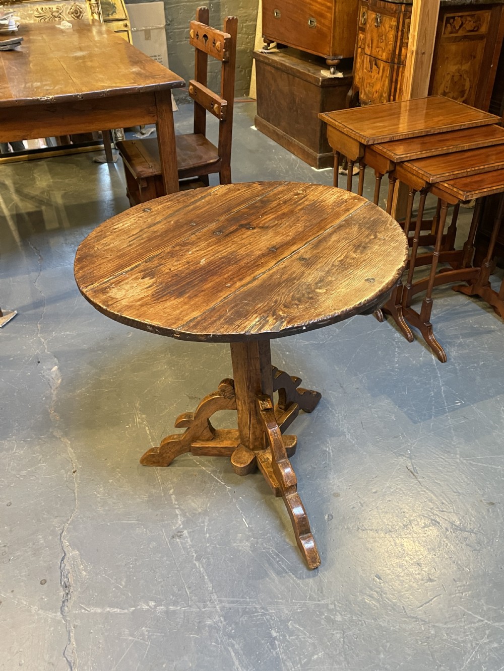 An 18th-century rustic pine pedestal table featuring a round plank top and carved tripod legs with a warm timber patina. View II