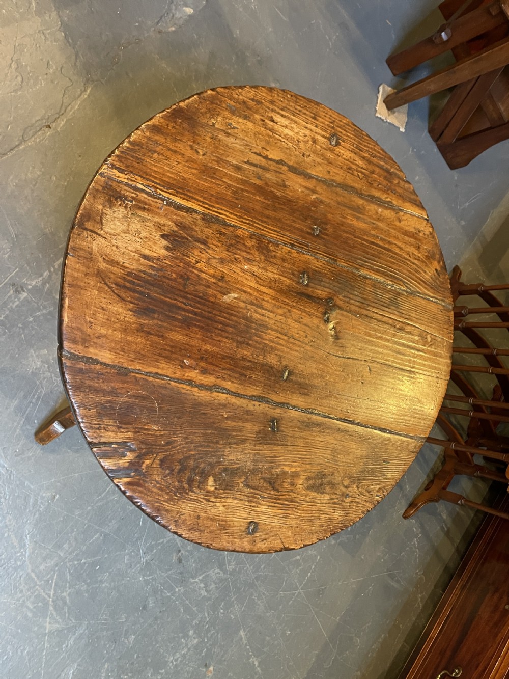 An 18th-century rustic pine pedestal table featuring a round plank top and carved tripod legs with a warm timber patina. View III