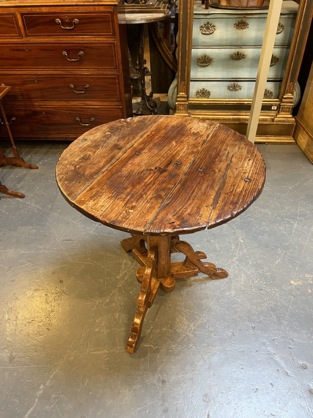 An 18th-century rustic pine pedestal table featuring a round plank top and carved tripod legs with a warm timber patina. View VIII