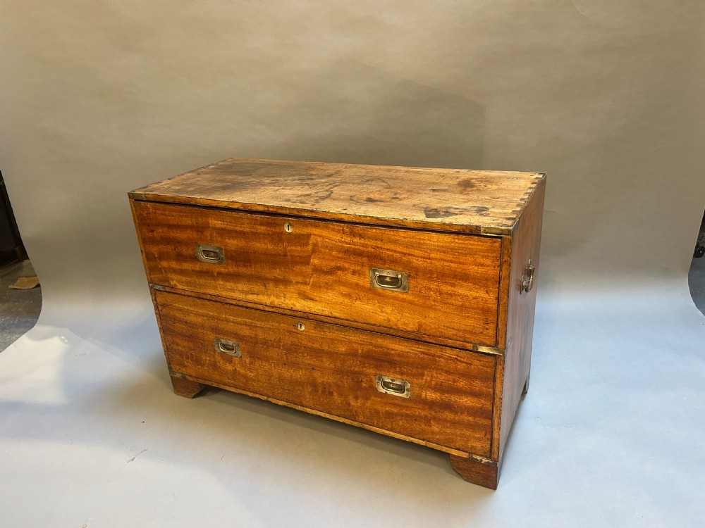 A nineteenth-century mahogany campaign chest featuring two wide drawers with flush brass handles, protective brass corner mounts, and side carrying handles. View II
