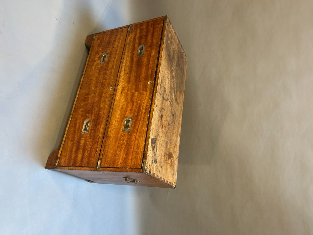 A nineteenth-century mahogany campaign chest featuring two wide drawers with flush brass handles, protective brass corner mounts, and side carrying handles. View III